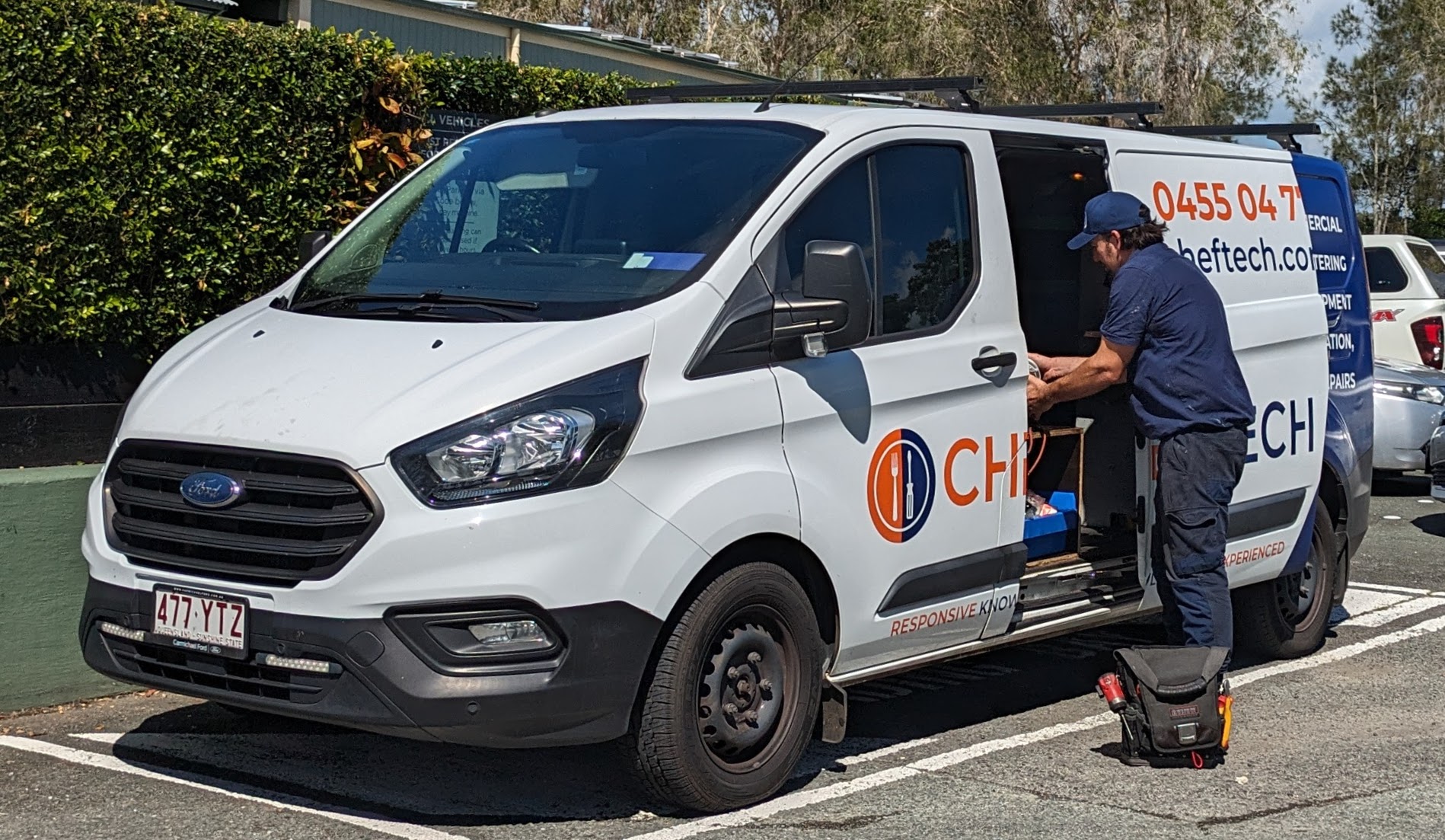 CHEFTECH technician loading parts from a branded service van on site